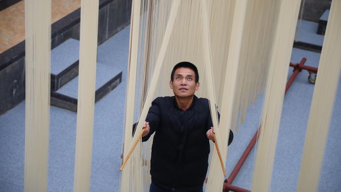 Penduduk desa mengeringkan mi di Desa Huangjiazhuang di Distrik Maiji, Kota Tianshui, Provinsi Gansu, China pada 30 November 2020. Mi buatan desa itu tidak hanya populer di kalangan penduduk setempat, tetapi juga laris terjual ke seluruh penjuru China melalui platform e-commerce. (Xinhua/Ma Xiping)