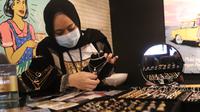 Petugas menunjukkan emas perhiasan yang dijual di Galeri 24, Jakarta, Selasa (15/12/2020). Harga emas hasil produksi PT Aneka Tambang Tbk (Antam) atau emas Antam kini turun Rp 1.000 per gram menjadi Rp 951 per gram pada perdagangan, Selasa (15/12). (Liputan6.com/Angga Yuniar)