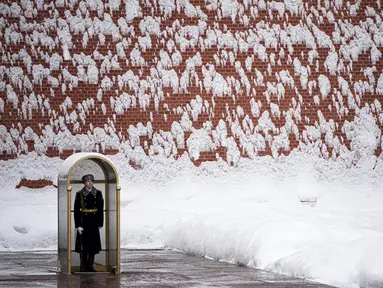 Seorang prajurit berdiri menjaga Makam Prajurit Tak Dikenal setelah hujan salju di Tembok Kremlin, Moskow, Rusia, 7 Februari 2022. (AP Photo/Alexander Zemlianichenko)