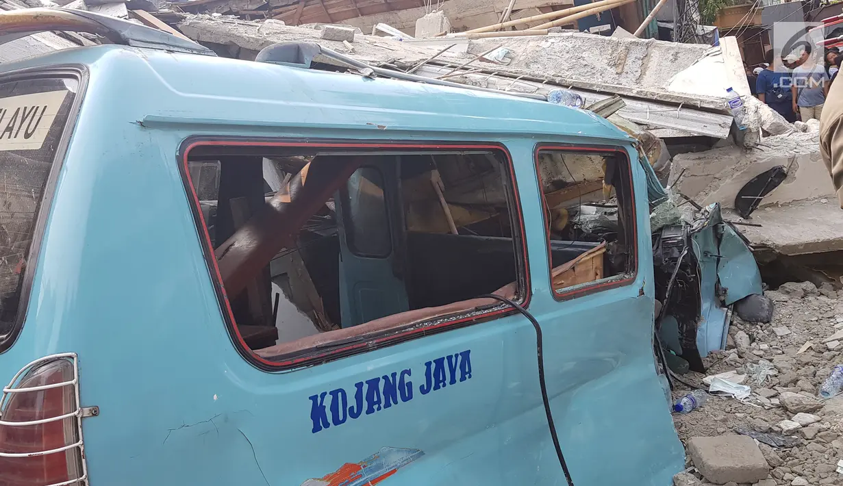 Sebuah angkot tertimpa reruntuhan rumah roboh di di  Jalan Pulo, Tanah Tinggi, Johar Baru, Jakarta Pusa, Jumat (26/4). Menurut saksi mata mengatakan rumah tersebut sedang dalam proses pembangunan yang sudah dilakukan selama kurang lebih satu tahun. (Liputan6.com/Herman Zakharia)