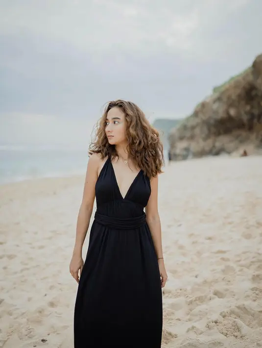 Dalam berbagai gaya pakaiannya, Naomi Zaskia terlihat cocok dengan baju hitam. Kali ini ketika berlibur ke pantai, wanita kelahiran 1996 itu tampil anggun dengan dress berwarna hitam. Rambutnya yang dimodel dengan gaya keriting, membuatnya makin cantik. (Liputan6.com/IG/@naonomnom)