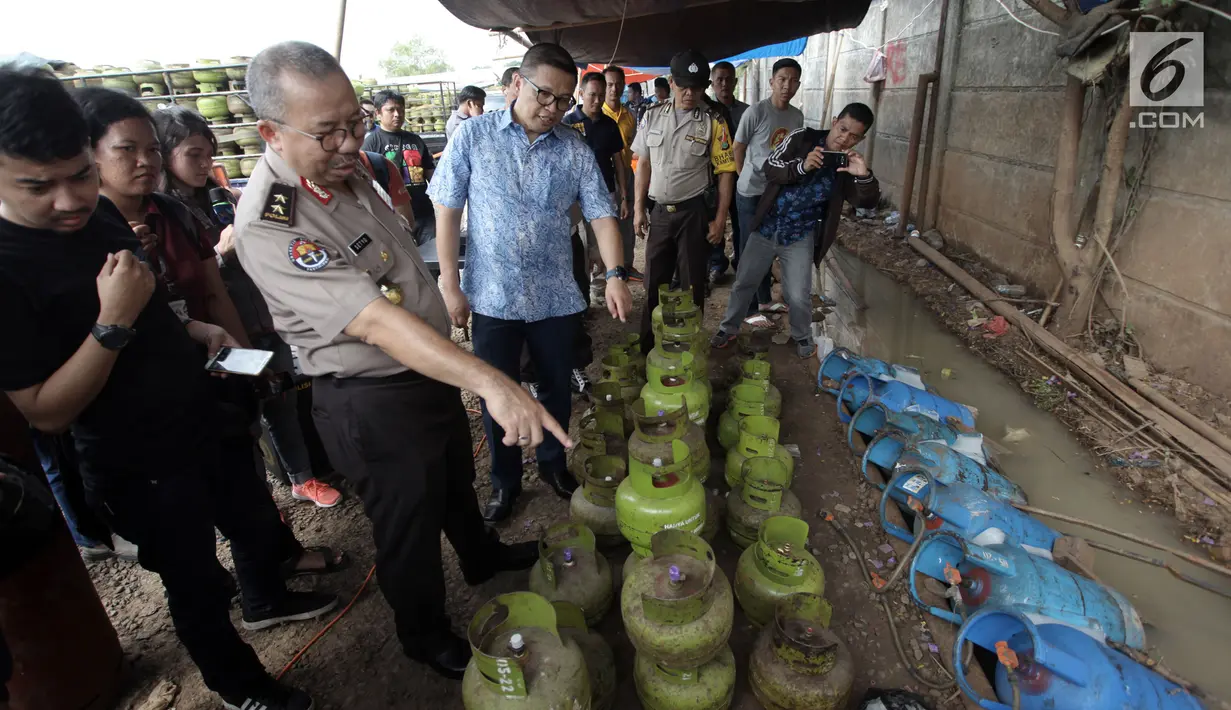 Kadiv Humas Mabes Polri Irjen Pol Setyo Wasisto memeriksa barang bukti tumpukan tabung gas yang diamankan seusai penggerebekan gas oplosan di wilayah Nerotog, Pinang, Tangerang, Jumat (12/1). (Liputan6.com/Arya Manggala)