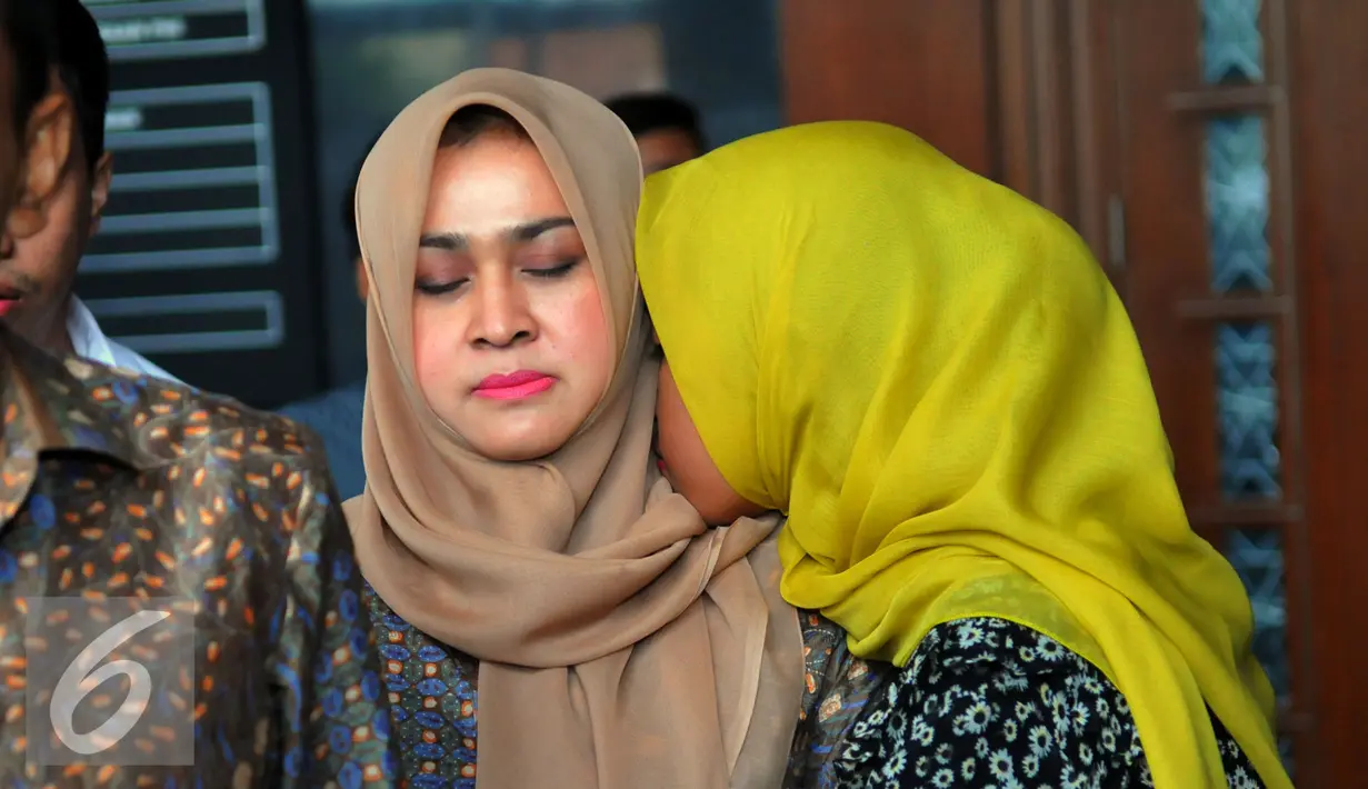 Anak Gatot Pudjo Nugroho memeluk sang ibu Evy Susanti usai menjalani sidang di Pengadilan Tipikor, Jakarta, Rabu (17/2). Jaksa menuntut Gatot dan Evy dengan denda sebesar Rp200 juta subsider lima bulan kurungan. (Liputan6.com/Faisal R Syam)