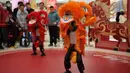 Para pengunjung menyaksikan robot humanoid yang mengenakan kostum tari singa tampil dalam acara pratinjau media sebuah festival kuil robot menjelang Tahun Baru Imlek di Beijing, China, Jumat 13 Februari 2026. (AP Photo/Vincent Thian)