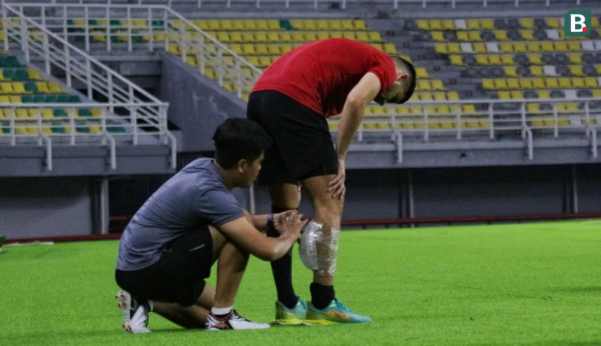 Seorang staf memasangkan es batu di bagian betis kanan dari pemain naturalisasi Timnas Indonesia, Sandy Walsh, saat menjalani latihan terpisah di Stadion Gelora Bung Tomo (GBT), Surabaya, Sabtu (10/6/2023) petang WIB. Pemain berusia 28 tahun tersebut mendapatkan cedera betis beberapa waktu lalu. (Bola.com/Wahyu Pratama)