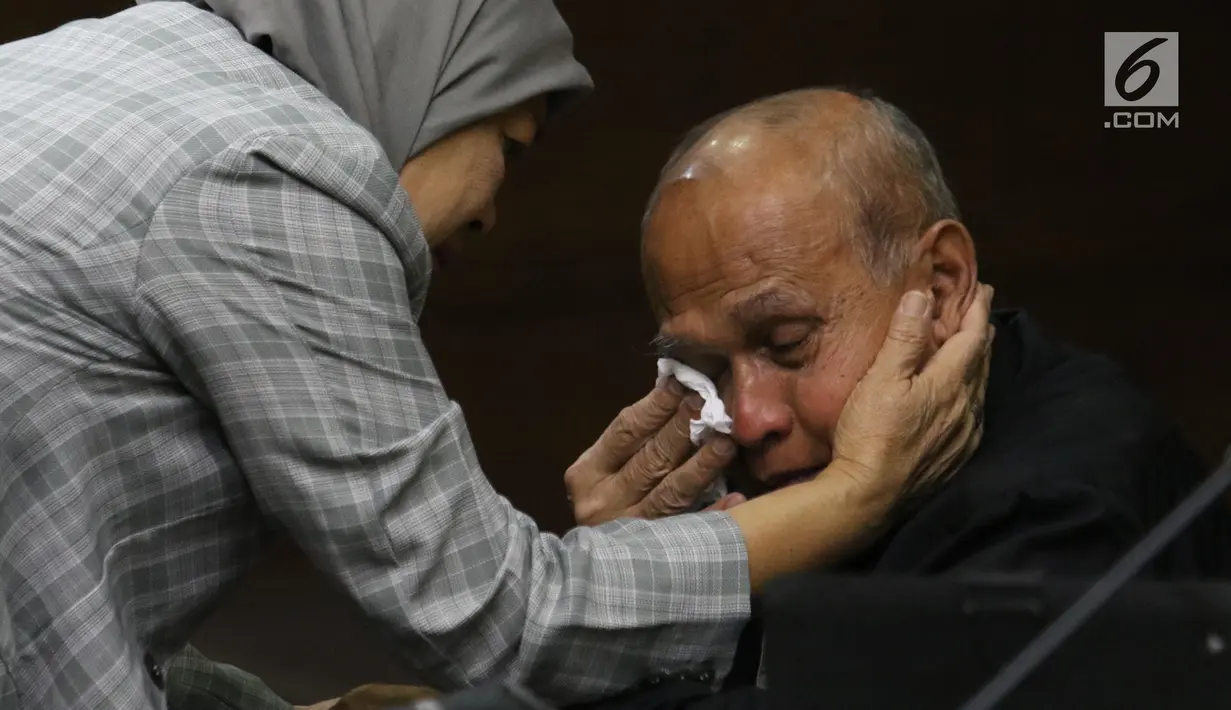 Dwitularsih menyeka air mata sang suami, Mantan Kepala Staf Komando Strategis Angkatan Darat (Kostrad) Kivlan Zen saat sidang perdana di Pengadilan Negeri Jakarta Pusat, Selasa (10/9/2019). Kivlan Zen menjalani sidang perdana kasus kepemilikan senjata api ilegal. (Liputan6.com/Angga Yuniar)