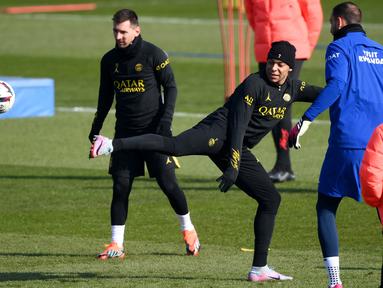 Penyerang PSG Kylian Mbappe (kanan) menendang bola melewati Lionel Messi selama sesi latihan di tempat latihan klub di Saint-Germain-en-Laye, sebelah barat Paris, Jumat (3/3/2023). PSG akan menjamu Nantes di Parc des Princes pada pekan ke-26 Ligue 1 2022/2023, Minggu, 5 Maret 2023 dini hari WIB. (Photo by FRANCK FIFE / AFP)