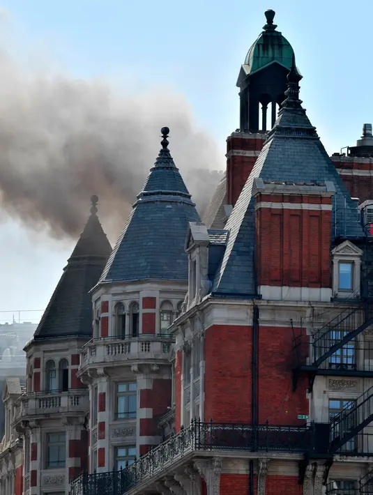 Asap hitam terlihat membubung dari atap Hotel Mandarin Oriental yang mengalami kebakaran di London, Inggris, Rabu (6/6). Menurut pihak pemadam kebakaran hingga saat ini belum diketahui penyebab kebakaran tersebut. (John Stillwell/PA via AP)
