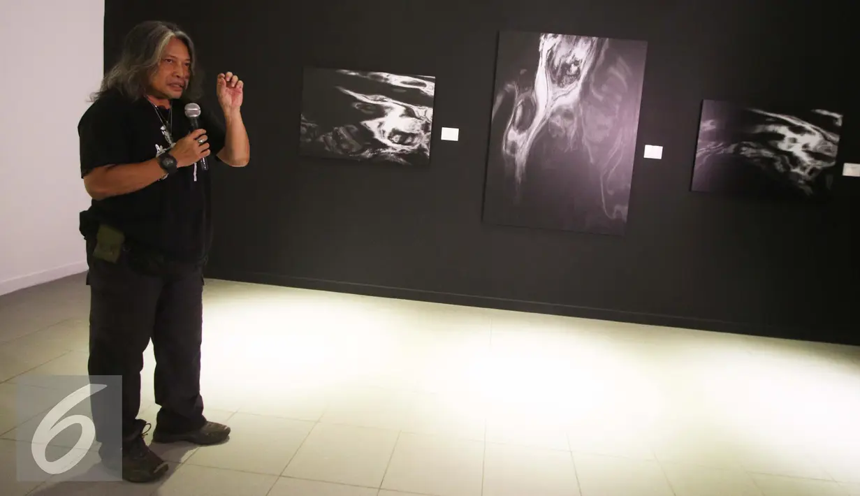 Kurator Galeri Foto Jurnalistik Antara Oscar Motuloh menjelaskan karya fotonya kepada pengunjung yang dipajang pada ajang pameran foto Abad Fotografi di Galeri Nasional, Jakarta, Selasa (15/11). (Liputan6.com/Gempur M. Surya)