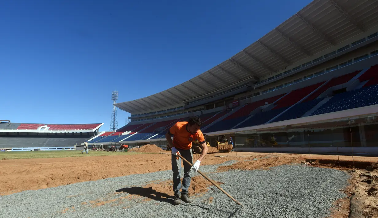 Seorang suporter Cerro Porteno saat membantu menyelesaikan pembangunan stadion baru di Asuncion, Paraguay (22/6). Cintanya dengan tim ini, puluhan suporter ini membantu menyelesaikan pembangunan stadion tersebut. (AFP Photo/Norberto Duarte)