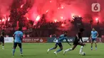 Suporter menyalakan flare saat menyaksikan laga Persija melawan Sabah FC pada laga uji coba internasional di Stadion Patriot Candrabhaga, Kota Bekasi, Minggu (5/6/2022). Pertandingan sepakbola kembali bisa disaksikan secara langsung setelah pemerintah melonggarkan aturan pemakaian masker di luar ruangan. (Liputan6.com/Helmi Fithriansyah)
