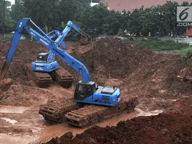 Pekerja menggunakan alat berat saat menyelesaikan pembuatan Waduk Kampung Rambutan, Jakarta, Kamis (26/4). Pemprov DKI Jakarta kembali melanjutkan proyek waduk seluas 12 hektare tersebut. (Merdeka.com/Iqbal Nugroho)