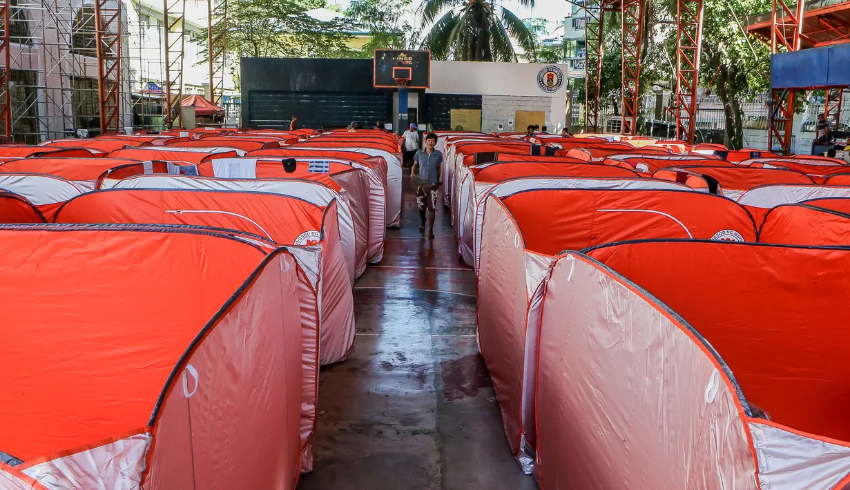 Warga berjalan di antara tenda-tenda modular bagi kaum tunawisma guna menghentikan penyebaran COVID-19 di sebuah lapangan basket beratap di Manila, 23 Maret 2020. Jumlah kasus infeksi virus corona meningkat menjadi 501, menurut Otoritas kesehatan Filipina, pada Selasa (24/3). (Xinhua/Rouelle Umali)