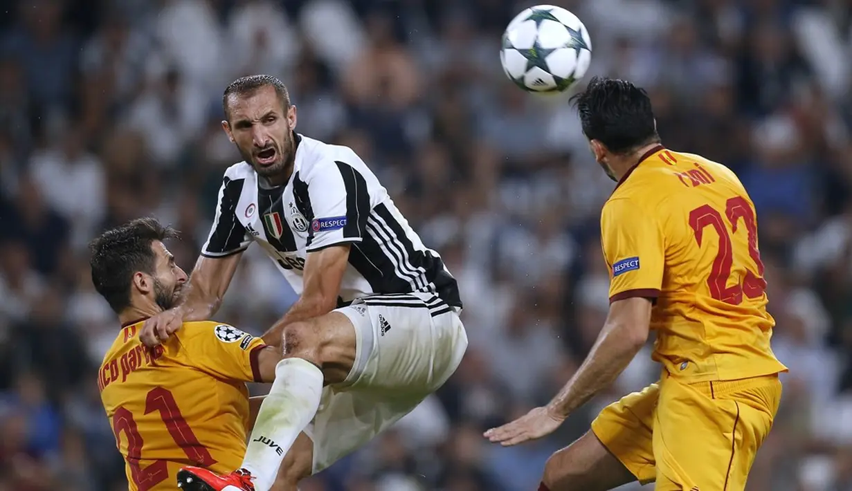 Pemain Juventus, Giorgio Chiellini, berebut bola dengan pemain Sevilla pada laga Liga Champions Grup H di Juventus Stadium, Turin, Kami (15/9/2016) dini hari WIB. (AFP/Marco Bertorello)
