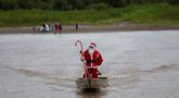 Relawan Jorge Alberto Barrozo, yang mengenakan kostum Sinterklas, berlayar dengan kano mengantarkan hadiah kepada anak-anak di komunitas tepi sungai di daerah pedesaan Careiro da Varzea, negara bagian Amazonas, Brasil pada Sabtu 20 Desember 2025. (Michael DANTAS/AFP)
