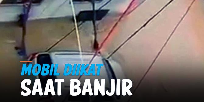 VIDEO: Seorang Pria Amankan Mobil dengan Ikatan Tali Saat Dilanda Banjir