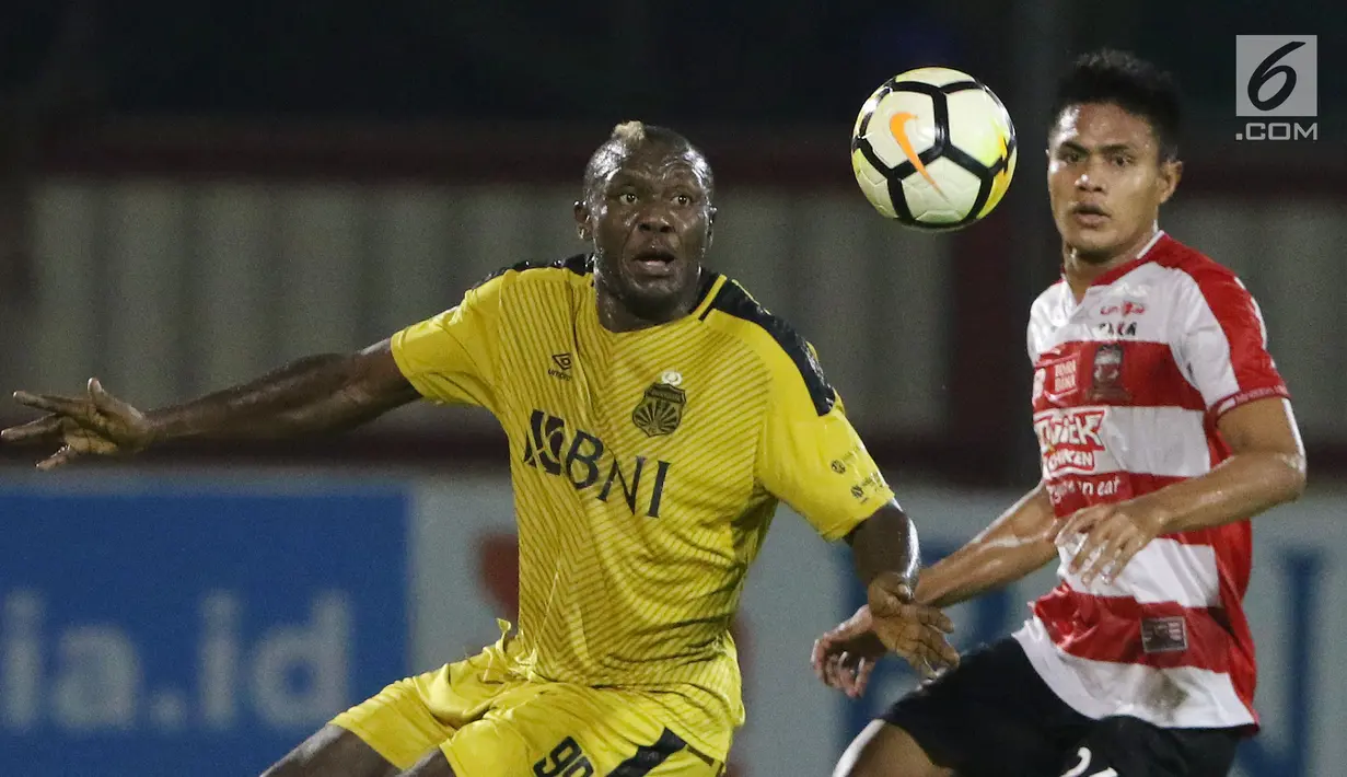 Pemain depan Bhayangkara FC, Herman Dzumafo Epandi (kiri) berebut bola dengan pemain Madura United, Fachrudin W Aryanto pada lanjutan Go-Jek Liga 1 Indonesia 2018 bersama Bukalapak di Stadion PTIK, Jakarta, Kamis (7/6). (Liputan6.com/Helmi Fithriansyah)