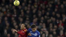 Bek Liverpool, Virgil van Dijk (kiri) berebut bola udara dengan pemain Everrton, Dominic Calvert-Lewin  pada pertandingan lanjutan Liga Inggris di Stadion Anfield, Rabu (4/12/2019). Liverpool menang telak 5-2 atas Everton. (AP Photo/Jon Super)