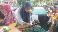 Petugas kesehatan dari Polresta Pekanbaru mengecek tensi dan memberikan vitamin kepada pekerja pelipatan surat suara Komisi Pemilihan Umum. (Liputan6.com/M Syukur)