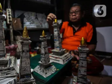 Sugito (68) menyelesaikan pembuatan miniatur Monas dari kertas koran bekas di Bank Sampah Tri Alam Lestari, Pesanggrahan, Jakarta Selatan, Rabu (9/6/2021). Pengolahan Kertas bekas itu dikumpulkan melalui bank sampah yang dikelola putrinya. (Liputan6.com/Johan Tallo)
