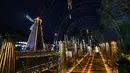 Pengunjung menyusuri koridor yang diterangi instalasi bambu di Desa Tangchang, Kota Hangzhou, Provinsi Zhejiang, China pada 13 November 2020. Kaya akan sumber daya bambu, Desa Tangchang menggelar pertunjukan cahaya, menampilkan berbagai instalasi lampu yang terbuat dari bambu. (Xinhua/Xu Yu)