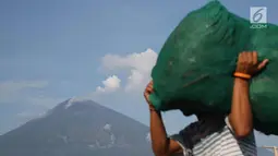 Asap tebal keluar dari puncak kawah Gunung Agung terlihat dari kawasan Amed, Karangasem, Bali, Kamis (7/12). Sepekan terakhir, aktivitas kawah Gunung Agung mulai tampak tenang, meskipun masih dalam status Awas. (Liputan6.com/Immanuel Antonius)