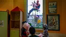 Orang-orang berpakaian seperti “Super Hero” mengantarkan telur Paskah kepada anak-anak yang dirawat di bangsal anak di klinik De Marchi, pada 28 Maret 2024 di Milan, Italia. (Piero Cruciatti/AFP)