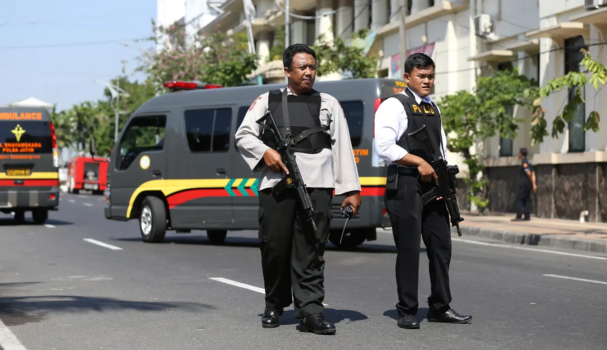 Aparat kepolisian bersenjata lengkap berjaga setelah serangan bom bunuh diri di Polrestabes Surabaya, Jawa Timur, Senin (14/5). Diduga, pelaku seorang pria dan wanita yang berboncengan dengan sepeda motor dan membawa seorang anak kecil (AP/Achmad Ibrahim)