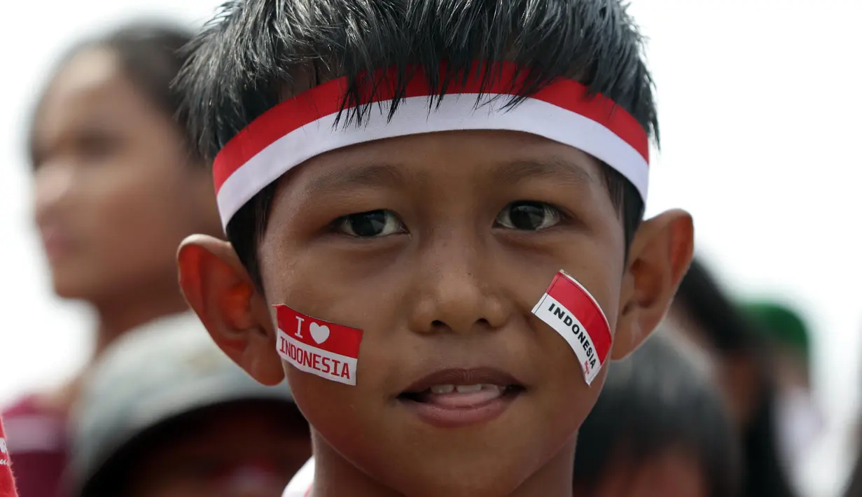 Anak-anak yang tergabung dalam Kelas Jurnalis Cilik melaksanakan Upacara Peringatan HUT RI ke-77 di Kawasan Kalibaru Barat, Cilincing, Jakarta, Rabu (17/8/2022). Memperingati Hari Kemerdekaan Indonesia ke-77, anak-anak yang tergabung dalam Kelas Jurnalis Cilik bersama para relawan melaksanakan upacara bendera dan beragam lomba. (Liputan6.com/Helmi Fithriansyah)