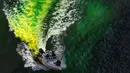 Petugas menggunakan kapal untuk menyemprotkan pewarna  hijau khusus ke sungai Chicago, AS selama perayaan St. Patrick's Day, 11 Maret 2017. Sungai itu setiap tahun mengalami perubahan warna demi memikat wisatawan. (John J. Kim/Chicago Tribune melalui AP)