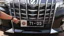 Seorang petugas menunjukan logo pada kendaraan dengan plat nomor khusus anggota DPR yang terparkir di Kompleks Parlemen, Senayan, Jakarta, Selasa (25/5/2021).  Penggunaan plat nomor khusus tersebut hanya menyempurnakan penggunaan atribut logo DPR. (Liputan6.com/Angga Yuniar)