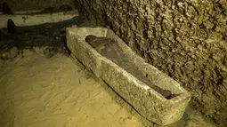 Mumi terbungkus kain linen ditemukan di ruang pemakaman di Provinsi Minya, Mesir, Sabtu (2/2). Usia mumi tersebut diperkirakan lebih dari 2.000 tahun. (AP Photo/Roger Anis)