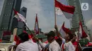 Sejumlah warga yang melintas mengibar-ngibarkan bendera Merah Putih saat melintasi kawasan Bundaran Hotel Indonesia, Jakarta, Sabtu (17/8/2024). (Liputan6.com/Angga Yuniar)