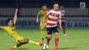 Bek Bhayangkara FC, M Fatcu Rochman (kiri) berusaha menahan pemain Madura United, Slamet Nurcahyono pada lanjutan Go-Jek Liga 1 Indonesia 2018 bersama Bukalapak di Stadion PTIK, Jakarta, Kamis (7/6). (Liputan6.com/Helmi Fithriansyah)