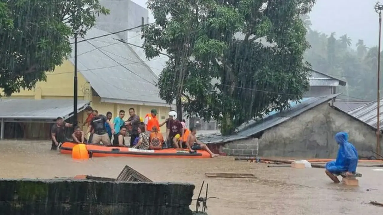 Personil Polri ikut mengevakuasi warga terdampak bencana banjir di Kota Manado, JUmat (27/1/2023).