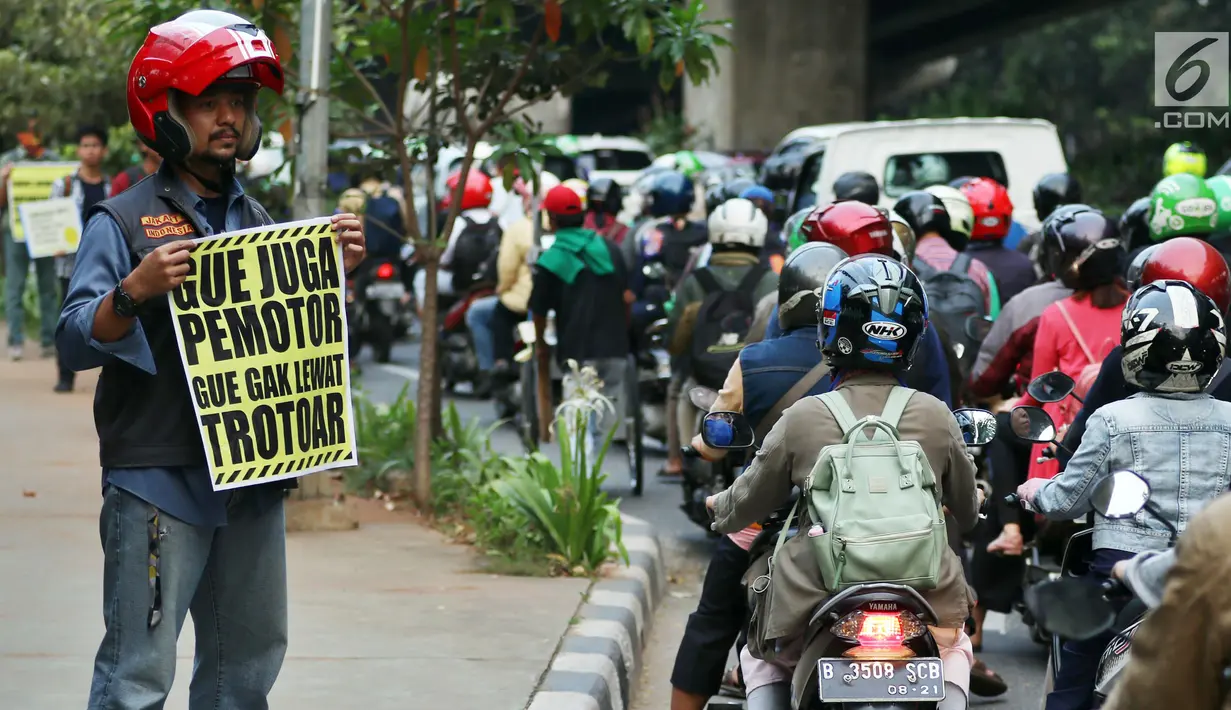 Aktivis Koalisi Pejalan Kaki membawa poster saat aksi peduli pejalan kaki di kawasan pedestrian Kasablanka, Jakarta, Kamis (22/8). Mereka menyerukan agar tidak menggunakan trotoar sebagai tempat parkir dan berjualan.(Liputan6.com/JohanTallo)