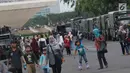 Warga bersama anak-anak berjalan-jalan di kawasan Monumen Nasional, Jakarta, Jumat (19/4). Libur panjang perayaan Paskah 2019 dimanfaatkan warga untuk berwisata di kawasan Monumen Nasional. (Liputan6.com/Helmi Fithriansyah)