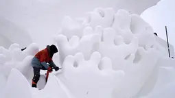 Seorang pemahat salju mengerjakan karya seni di kompleks Pameran Seni Pahatan Salju Internasional Pulau Matahari Harbin ke-33 di Harbin, Provinsi Heilongjiang, China pada 10 Desember 2020. Ajang tersebut diperkirakan akan dibuka pada pertengahan hingga akhir Desember mendatang. (Xinhua/Wang Jianwei)