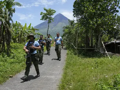 Polisi melakukan patroli di "zona bahaya permanen" untuk memeriksa pengungsi yang kembali atau masih tinggal di rumah mereka di Desa Calbayog, Kota Malilipot, Provinsi Albay, Filipina, Kamis (15/6/2023). (AP Photo/Aaron Favila)