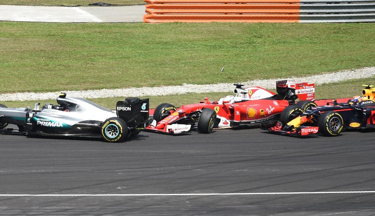 Pebalap Ferrari, Sebastian Vettel, bersenggolan dengan pebalap Mercedes, Nico Rosberg (kiri), saat balapan F1 GP Malaysia di Sirkuit Sepang, Minggu (2/10/2016). (AFP/Mohd Rasfan)