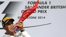 Selebrasi pembalap Formula Satu dari tim Mercedes, Lewis Hamilton, usai memenangi GP Inggris yang dihelat di Sirkuit Silverstone, (6/7/2014). (REUTERS/Francois Lenoir)