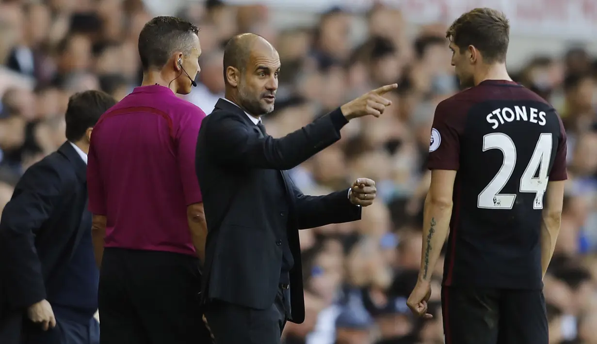 Pelatih Manchester City, Pep Guardiola memberi arahan kepada John Stones saat melawan Tottenham Hotspur pada laga Premier League di Stadion White Hart Lane, London, Minggu (2/10/2016). (AP/Frank Augstein)