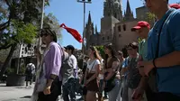 Sekelompok turis mengikuti pemandu wisata di Plaza de la Catedral di Barcelona, ​​​​pada 11 Mei 2022. Pengunjung sekali lagi memadati jalan-jalan sempit di kawasan Gothic Barcelona yang sempit saat perjalanan global bangkit kembali dari pandemi COVID-19, menghidupkan kembali kekhawatiran atas pariwisata massal di kota pelabuhan Spanyol.
(LLUIS GEN / AFP)