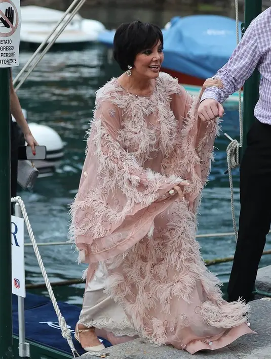 Sementara sang ibu, Kris Jenner, mengenakan gaun berbulu warna peach dari Dolce & Gabbana. (Instagram/enews).