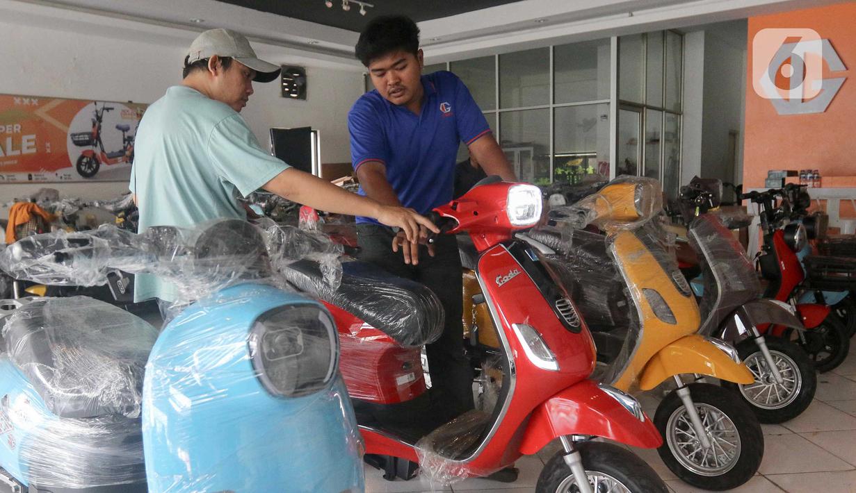 Pegawai gerai memberikan penjelasan kepada calon pembeli kendaraan bermotor listrik di Jatinegara, Jakarta, Rabu (29/5/2024). (Liputan6.com/Herman Zakharia)