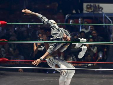 Pebalap Mercedes GP, Lewis Hamilton, beraksi bersama pegulat Meksiko di Coliseo Arena, Mexico City, (28/10/2015). (Reuters/Henry Romero)