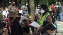 Polisi berjalan di antara warga lansia yang sedang menunggu untuk disuntik vaksin Sinovac di Alun-Alun Bekasi, Jawa Barat, Rabu (23/2/2022). Sebanyak 600 dosis vaksin Sinovac disiapkan pemerintah setempat untuk warga lansia guna mencegah penyebaran COVID-19. (Liputan6.com/Herman Zakharia)