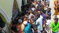 Jemaah salah satu masjid yang ada di Kota Gorontalo berebut makanan usai salat jumat (Arfandi/Liputan6.com)