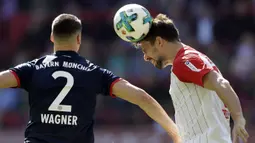 Striker Bayern Munchen, Sandro Wagner, duel udara dengan bek FC Augsburg, Rani Khedira, pada laga Bundesliga di WWK Arena, Augsburg, Sabtu (7/4/2018). Bayern Munchen menang 4-1 atas FC Augsburg. (AP/Matthias Schrader)