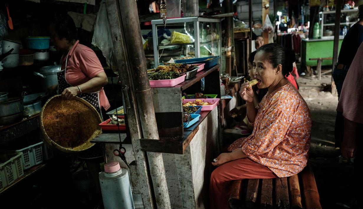 Airlangga Hartarto menambahkan bahwa pemerintah telah menyiapkan langkah-langkah konkret untuk mendorong perputaran ekonomi di akhir tahun. Tampak dalam foto, seorang wanita menikmati sarapan khas Sunda di sebuah warung makan di pasar pinggir jalan di Jakarta pada Sabtu 8 November 2025. (YASUYOSHI CHIBA/AFP)